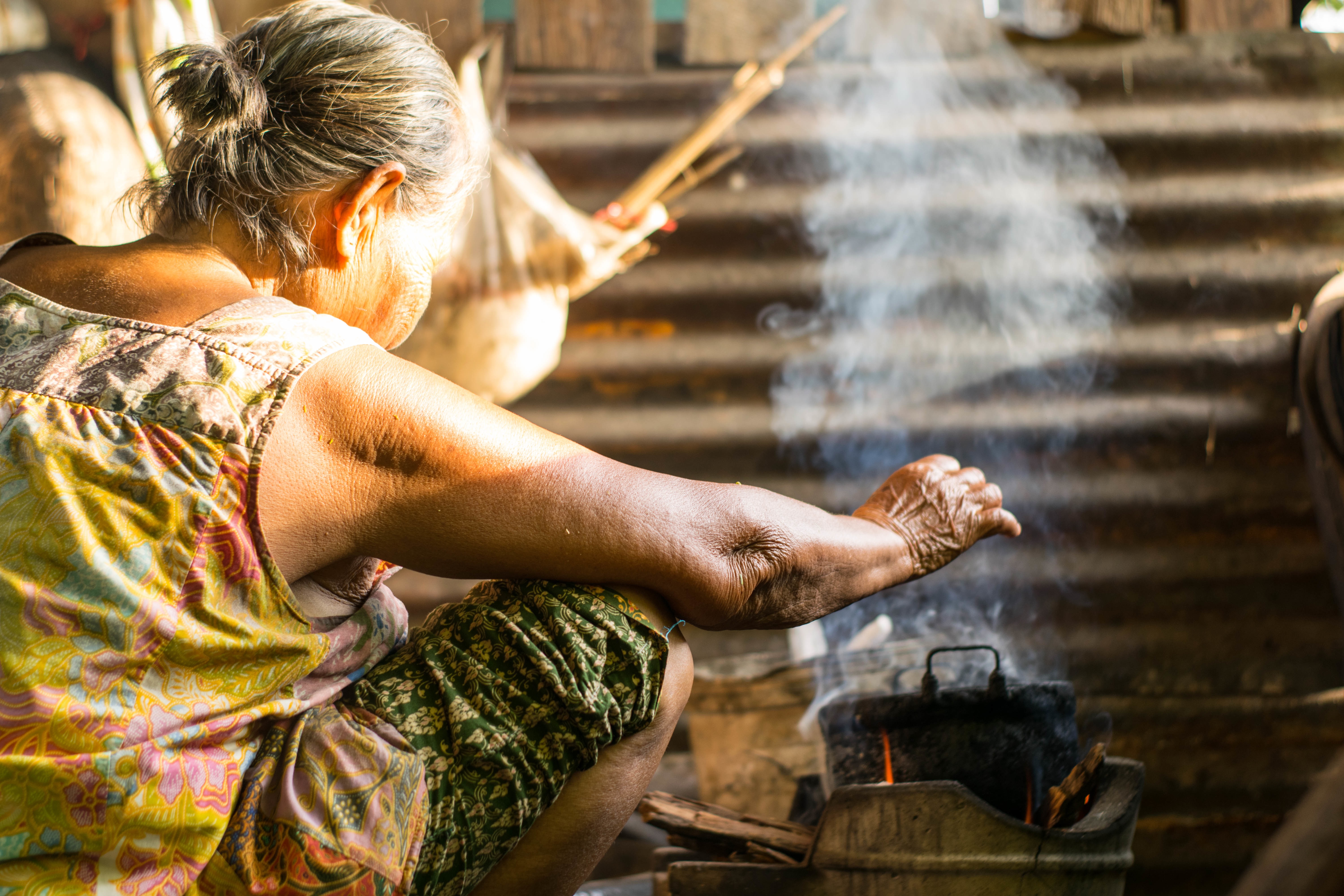 Rural people are cooking food with firewood, dried wood, with smoke